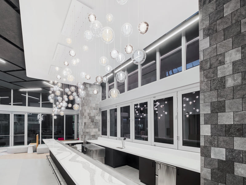Four interlocking Nimbus and Kadur chandeliers reading as one sky above the Yotel Miami lobby