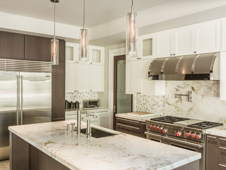 Nava hand-blown glass pendants by Shakúff above a marble kitchen island